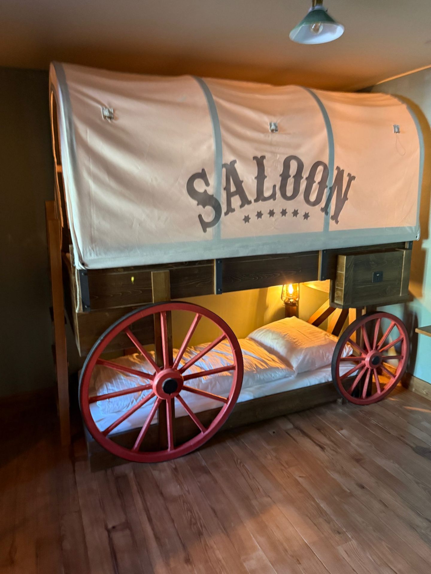 Riverside Lodge – Planwagen-Etagenbett Saloon mit roten Speichenrädern