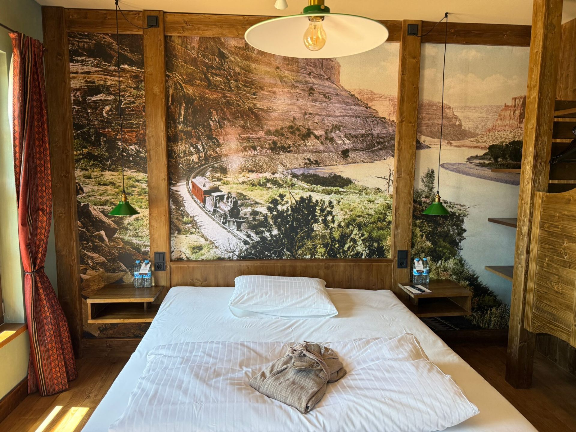 Riverside Lodge – Schlafzimmer mit Canyon-Wandbild und historischer Eisenbahn