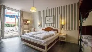 Doppelzimmer mit Holzkopfteil, Terrassenzugang und Streifentapete