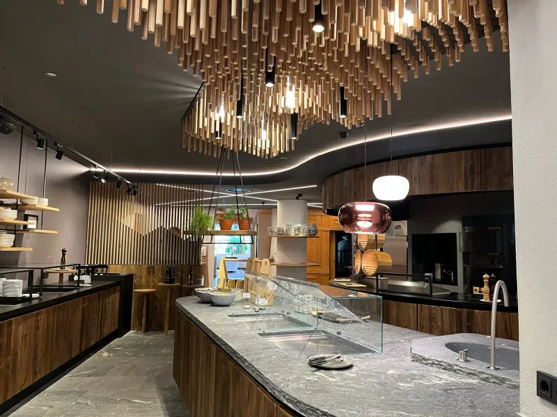 Buffetbereich mit Holzstäbe-Deckeninstallation und Naturstein-Theke