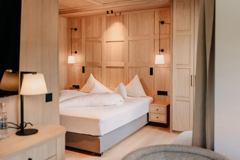 Zimmer – Bett mit Holzpaneel