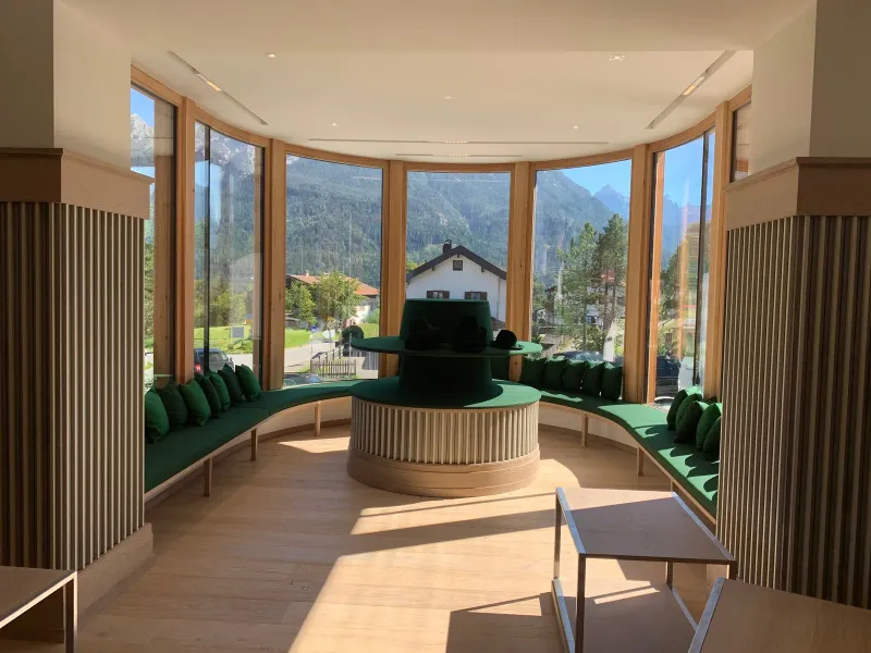 Rundverglasung mit Sitzlandschaft und Hutpräsentation