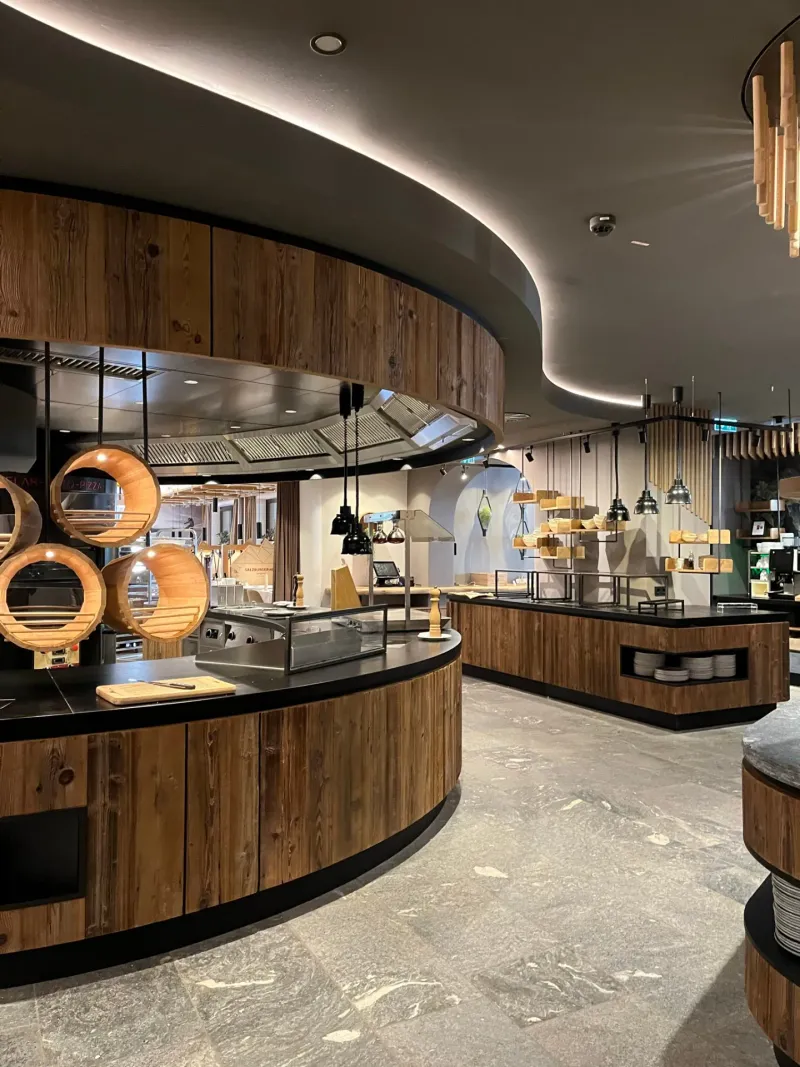 Geschwungener Buffetbereich mit Altholz und LED-Deckenband