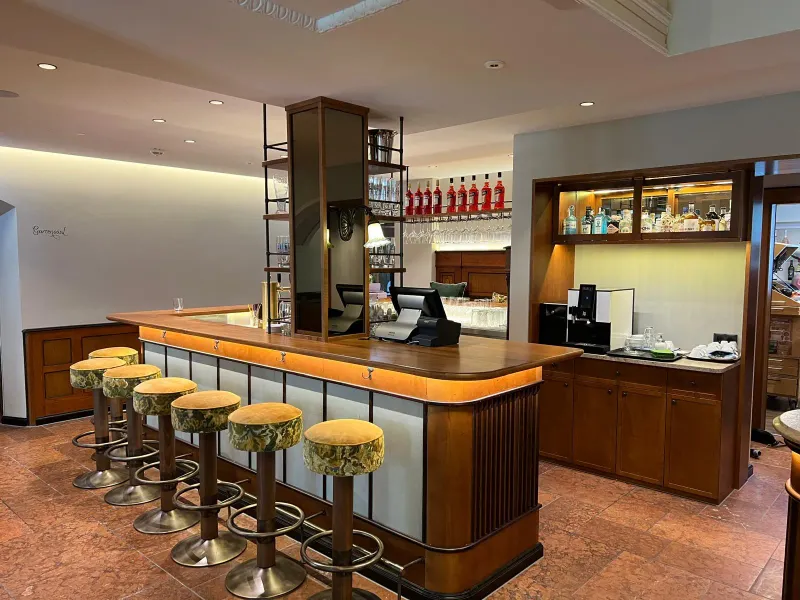 Gesamtansicht Lobbybar mit Barhockern und Glasregal